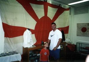 Charles and Austin in front of a Japanese commanders flag.